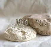 Anillo plateado de alpaca con diseño de ondas.