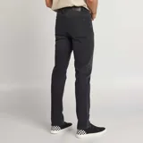Pantalón jean de corte slim color gris oscuro, con bolsillos delanteros y traseros, y cierre con cremallera y botón.