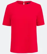 Blusa blanca de poliéster con cuello redondo, mangas cortas, cierre trasero en forma de gota, pequeñas aberturas laterales y acabados en pespuntes en las mangas y el cuello.