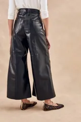 Pantalón negro de cuero vegano, corte wide leg y tiro alto.