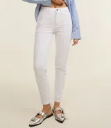Pantalón skinny blanco de sarga con cintura mediana, trabillas, cierre con botón y cremallera, bolsillos delanteros y traseros.