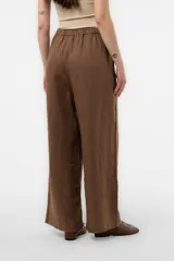 Pantalon de lino verde militar, de calce relajado y pierna amplia, con cintura elastizada, boton delantero y pinzas en el frente.