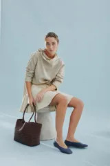 Cartera tote de cuero vacuno trenzado a mano, color bordó, de diseño espacioso con asas firmes.
