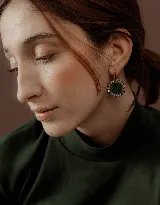 Aros colgantes con base de acero quirúrgico dorado, dije circular de resina verde oscuro y borde de strass.