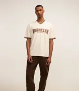 Pantalón baggy negro de sarga de algodón, con cintura fija con trabillas, botón contrastante y cierre por cremallera oculto, bolsillos laterales y traseros. Modelo holgado de corte recto y ancho.