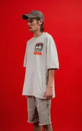 Remera de algodón premium color gris claro, corte oversize, con cuello redondo y manga corta. Presenta un estampado frontal pequeño con dos personajes de Disney (Mickey y Minnie) en llamas con el texto "THE FLAME OF LOVE".