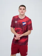 Remera de entrenamiento Umbro del Club Nacional de Football, modelo Press, para hombre. Diseño en tonos de rojo con patrón estampado tipo humo o abstracto, cuello redondo y mangas cortas. Incluye el logo de Umbro y el escudo del club en el pecho.
