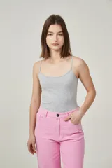 Musculosa de bretel fino color crudo, corte ajustado al cuerpo y escote redondo.