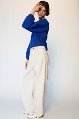 Jeans de tiro medio con diseño barrel, corte holgado que se estrecha hacia el tobillo y cinco bolsillos. Presenta costuras a contraste y cierre frontal con cremallera y botón.