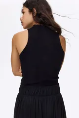 Top negro en punto acanalado de mezcla suave de viscosa, con cuello tortuga y diseño sin mangas.