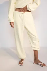 Pantalón jogger de tiro alto y color azul marino, con cintura elástica ajustable mediante cordones con herretes metálicos y puños elásticos en los tobillos.