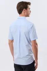 Camisa sport celeste de manga corta con cuello abotonado y bolsillo frontal en el pecho.