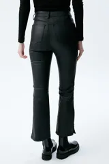 Pantalón de jean negro de tiro medio/alto con silueta levemente acampanada desde la rodilla.