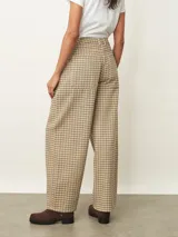 Pantalón tipo jean de corte recto y tiro medio, con estampado de cuadros en tonos beige y marrón. Cuenta con cierre frontal, bolsillos laterales y trabillas para cinturón.