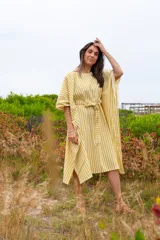 Vestido túnica a rayas verticales color mostaza y blanco, con cuello redondo, mangas cortas abullonadas y lazo para atar en la cintura.