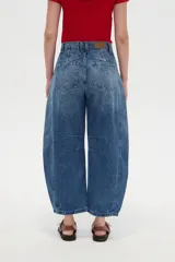 Pantalón de jean blanco de tiro medio, con diseño de silueta barrel, bolsillos clásicos y costuras con pinzas decorativas en la zona de las rodillas.