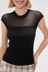 Remera de punto al cuerpo con diseño calado en la parte superior y cuello redondo, de manga corta.