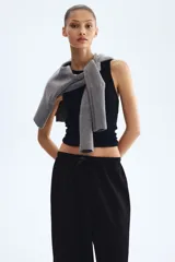 Pantalón negro de tiro alto, confeccionado en tejido texturizado con corte holgado y piernas amplias. Cuenta con cintura elástica fruncida y cordón ajustable.