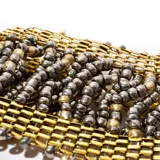 Brazalete de bijouterie con mostacillas color dorado y marrón.