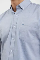 Camisa celeste de algodón con cuello abotonado, manga larga con puños abotonados y bolsillo en el pecho. Corte clásico.