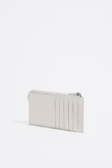 Monedero rectangular negro de cuero con cierre de cremallera, asa de cuero con ojetes metálicos y logo estampado.