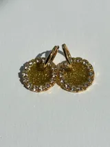 Aros colgantes dorados con base de resina brillante y borde de strass, con arito de acero quirúrgico.