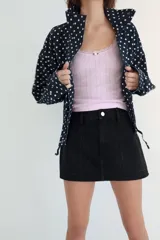 Falda pantalón de tiro medio confeccionada en tejido denim azul con costuras verticales decorativas, bolsillos delanteros y cierre frontal con cremallera y botón metálico.