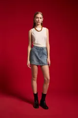 Minifalda de jean en color natural, con diseño recto, bolsillos y detalles de tachas en los laterales.
