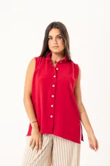 Camisa roja sin mangas con cuello mao adornado con un volado y cierre frontal con botones.