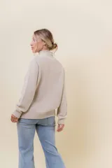 Polera de tejido de punto con textura marcada, cuello alto y diseño oversize con hombros caídos y terminaciones acanaladas.