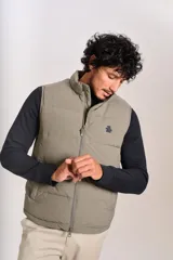 Chaleco puffer de corte regular, color beige, con cierre frontal y cuello alto. Presenta un diseño acolchado horizontal y logo bordado en el pecho.