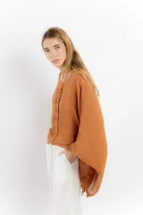 Blusa color rosa pálido de lino con mangas amplias y detalle de costuras en el frente.