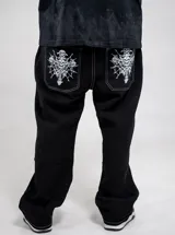 Jean negro de corte regular fit, con bolsillos traseros amplios que cuentan con un estampado gráfico en color blanco de calaveras y diseño gótico.