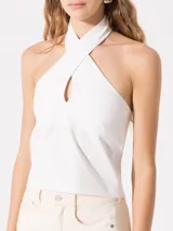 Top blanco de punto con cuello halter cruzado y broche snap en la espalda.