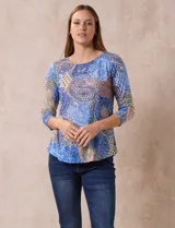 Blusa de modal estampada con motivos paisley en tonos azules, naranjas y amarillos. Tiene escote redondo y mangas tres cuartos.