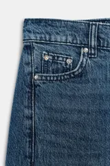 Jeans baggy de tiro medio con pernera holgada, diseño de cinco bolsillos y bajo acabado en vuelta. Cuenta con cintura elástica en la espalda y cierre frontal con cremallera y botón.