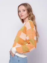 Sweater de tejido de punto con diseño jaquard a cuadros en tonos rosa y verde. Es de manga larga y cuello a la base.