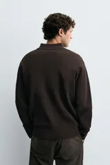 Polo de punto con textura, corte regular fit, cuello solapa con cierre frontal de tres botones, manga larga y acabados en rib.