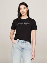 Remera negra de algodón orgánico con cuello redondo y mangas cortas. Presenta el logo script de Tommy Hilfiger bordado en blanco en el pecho y el logo de Tommy Hilfiger bordado en la manga.
