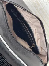 Bandolera negra de cuero con textura de cocodrilo, correa ancha con el nombre de la marca y detalles en blanco.