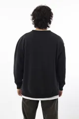 Buzo negro de corte oversize con logo bordado en el pecho.