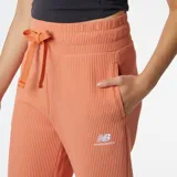 Pantalón New Balance de pana color salmón, de corte ancho y cintura alta con cordón ajustable. Presenta logo bordado en la cadera.