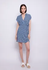 Vestido corto con estampado geométrico en tonos de azul, blanco y negro. Tiene escote en V, cuello camisero, mangas cortas y corte en la cintura.