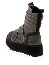 Bota tipo aviador de color gris con detalles en negro y tiras ajustables con velcro. Presenta una suela de plataforma gruesa con diseño dentado y puntera reforzada en negro.