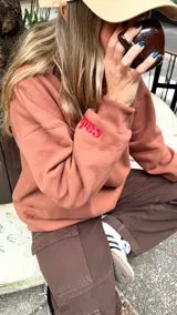 Buzo tipo canguro de calce oversize, color marrón, con cuello alto y diseño liso.