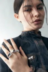 Set de anillos plateados con detalles de vidrio.