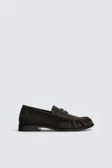 Mocasín de vestir confeccionado en piel con acabado de serraje, presenta un diseño clásico con detalle de antifaz en el empeine y suela a contraste con un ligero tacón.