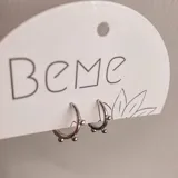 Par de aros argolla plateados con tres bolitas decorativas.