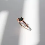 Anillo oro rosa con dije rectangular y brillantes negros engarzados en el dije y en la banda.
