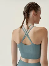 Top deportivo negro de sujeción media con canales para un ajuste perfecto. Presenta patrón delantero halter, tejido Air_feel, tecnología 3D y tirantes finos cruzados en la espalda.